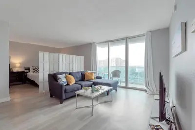 a living room with a blue couch and a table at Great apartment in Hollywood with side ocean view! Direct access to the beach! 14th floor in Hollywood