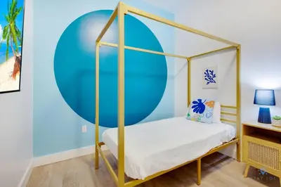a bedroom with a canopy bed in front of a blue wall at Amazing Pool - Balcony - Up To 6 - Near Beach in Hollywood