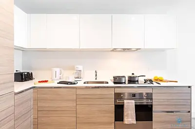 a kitchen with white cabinets and a stove top oven at Rooftop Pool, Broad-walk & Near Beach in Hollywood