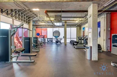 a gym with several treadmills and cardio machines at Rooftop Pool - Hot Tub - Gym - Near Beach in Hollywood