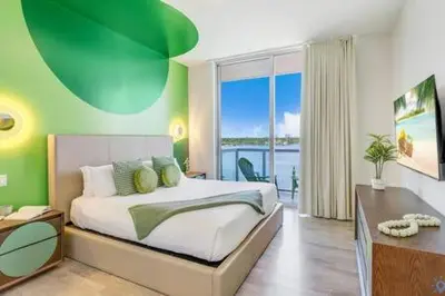 a bedroom with a bed with a green wall at Lovely Apartment-Rooftop Oasis - Bay View in Hollywood
