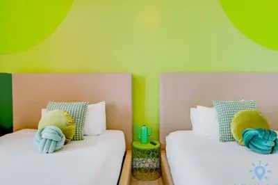 two beds in a room with green and yellow walls at Lovely Apartment-Rooftop Oasis - Bay View in Hollywood