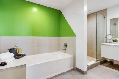 a bathroom with a white tub and a green wall at Lovely Apartment-Rooftop Oasis - Bay View in Hollywood