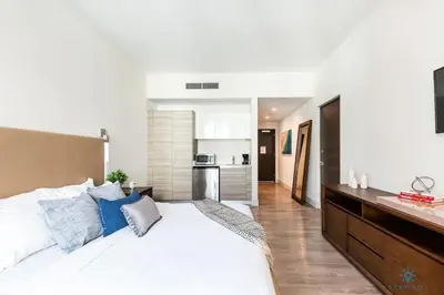 a bedroom with a large white bed with blue pillows at Rooftop Pool - Hot Tub - Hollywood Beach Broad - walk in Hollywood