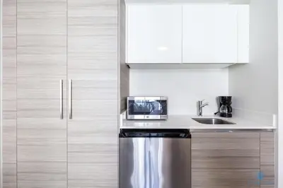 a kitchen with white cabinets and a stainless steel refrigerator at Rooftop Pool - Hot Tub - Hollywood Beach Broad - walk in Hollywood