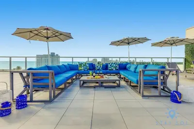 a patio with a blue couch and chairs and umbrellas at Rooftop Pool - Balcony - Hollywood Beach - Gym in Hollywood