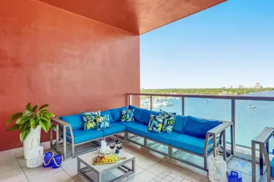 a blue couch on a balcony with a view of the water at Rooftop Pool - Balcony - Hollywood Beach Boardwalk in Hollywood