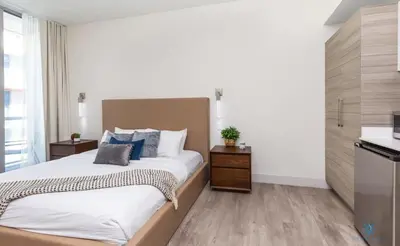 a bedroom with a large bed and a kitchen at Hot tub & Rooftop pool - Near Beach in Hollywood