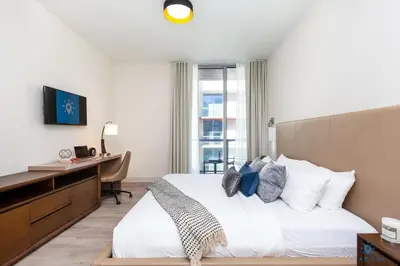 a bedroom with a bed and a desk with a computer at Hot tub & Rooftop pool - Near Beach in Hollywood