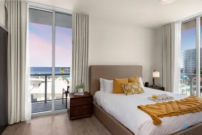 a bedroom with a large bed and a large window at Balcony - Hollywood Beach Broad-walk - Rooftop Pool in Hollywood