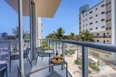 a balcony with a table and chairs on top of a building at Ocean View - Balcony - Rooftop Pool - Hollywood Beach in Hollywood