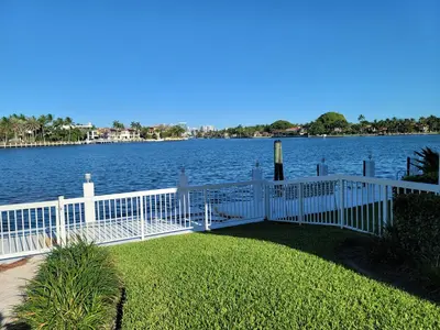 a white fence next to a body of water at WaterFront 4BR 3B,Intercoastal,Pool,5 min walk to beach-7 in Fort Lauderdale