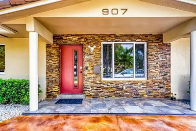 a brick house with a red door and a window at Hollywood Villa close to the BEACH w/HEATED POOL in Hollywood