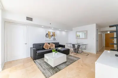 a living room with a black couch and a table at 4BR APT with Bay View at Brickell, Free Parking in Miami