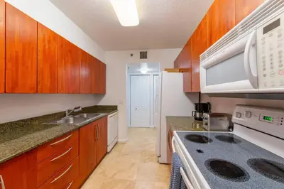 a kitchen with wooden cabinets and a stove top oven at 4BR APT with Bay View at Brickell, Free Parking in Miami