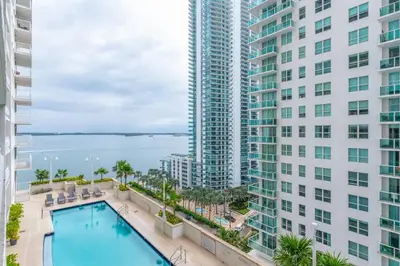 an apartment with a swimming pool and two tall buildings at 4BR APT with Bay View at Brickell, Free Parking in Miami