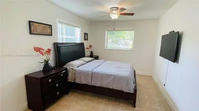 a bedroom with a bed and a ceiling fan at El Shaddai Faithfully Beach in Hollywood
