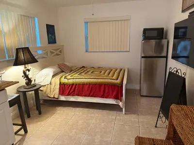 a small bedroom with a bed and a refrigerator at El Shaddai Faithfully Beach in Hollywood