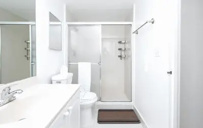 a white bathroom with a shower and a toilet at Beautiful 2 Bedroom Apartment on Hollywood Beach in Hollywood