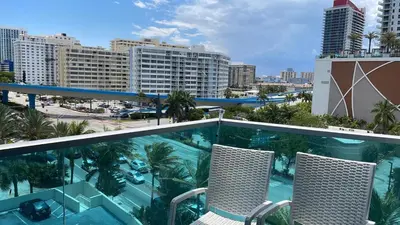 a balcony with two chairs and a swimming pool at Beautiful 2 Bedroom Apartment on Hollywood Beach in Hollywood