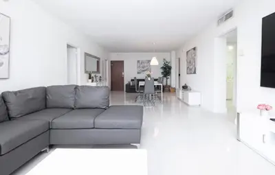 a living room with a couch and a dining room at Beautiful 2 Bedroom Apartment on Hollywood Beach in Hollywood