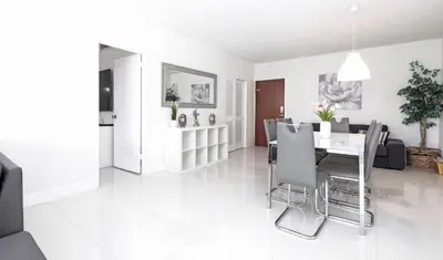 a white living room with a table and chairs at Beautiful 2 Bedroom Apartment on Hollywood Beach in Hollywood