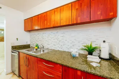 a kitchen with wooden cabinets and a sink at Amazing 2 BR APT at Brickell, Free Parking in Miami