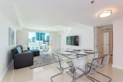 a living room with a table and chairs and a couch at Stunning 2BR with Ocean View at Brickell, Free Parking in Miami