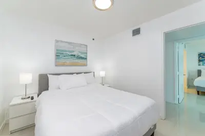 a white bedroom with a white bed and a window at Bright and Cozy 2BR at Brickell, Free Parking in Miami