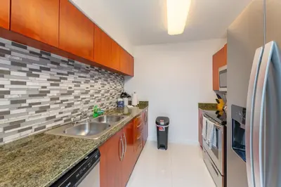 a kitchen with a sink and a refrigerator at Bright and Cozy 2BR at Brickell, Free Parking in Miami
