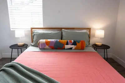 a bedroom with a bed with a pink blanket and two lamps at Casa MIA central location, free parking, fully equipped in Miami