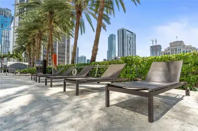 a row of chaise lounges in front of palm trees at Biscayne Bay View Stay Pool Hot Tub and Amenities in Miami