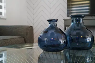 two blue glass vases sitting on a glass table at Blue Door Duplex Renovated Parking and Designed in Cutler Bay