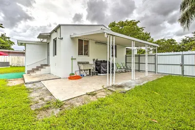 a white house with a patio and a fence at Central Miami Home about 10 Mi to Local Beaches! in Miami