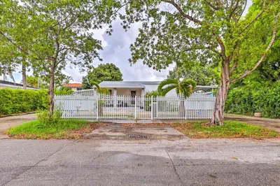 a white fence in front of a house at Central Miami Home about 10 Mi to Local Beaches! in Miami