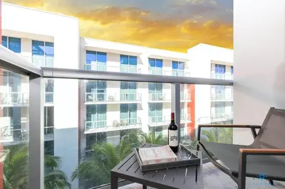 a bottle of wine sitting on a table on a balcony at Hollywood Beach Broad-walk - Pool - Gym & Hot Tub in Hollywood