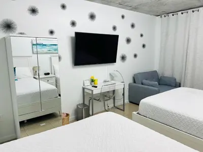 a bedroom with a bed and a tv on a wall at Classy 2BD 2BTH at Midblock with FREE PARKING in Miami