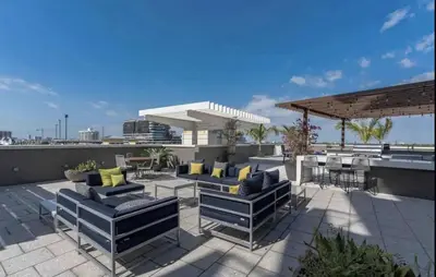a patio with couches and tables on a roof at Classy 2BD 2BTH at Midblock with FREE PARKING in Miami