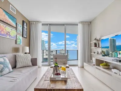 a living room with a couch and a large window at Beachside Contemporary Residence in Lyfe in Hollywood