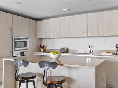 a kitchen with two bar stools and a counter at Beachside Contemporary Residence in Lyfe in Hollywood