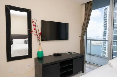 a bedroom with a mirror and a tv on a wall at W Hotel Miami Stunning Private Condo With Access to All Hotel Amenities in Miami