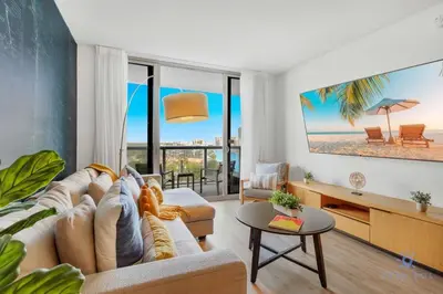 a living room with a couch and a view of the beach at Infinite Views with Amazing Pool plus Gym, Near Beach in Hallandale Beach