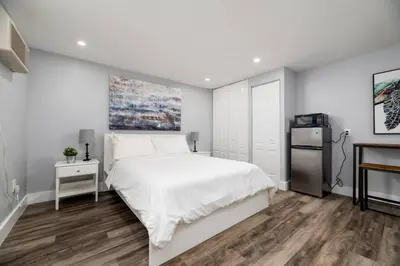a white bedroom with a bed and a refrigerator at Shell on the Beach 107 - RENOVATED in Hollywood