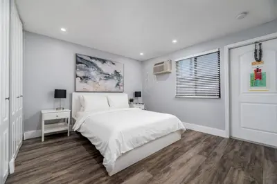 a white bedroom with a bed and a window at Shell on the Beach 104 - RENOVATED in Hollywood