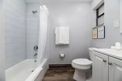 a white bathroom with a toilet and a bath tub at Shell on the Beach 105 - RENOVATED in Hollywood