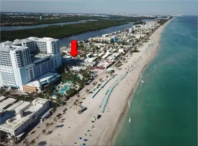 an aerial view of a beach with a red arrow at Shell on the Beach 106 - RENOVATED in Hollywood