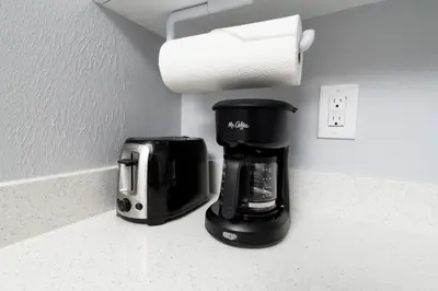 a coffee maker on a counter next to a paper towel at Shell on the Beach 106 - RENOVATED in Hollywood