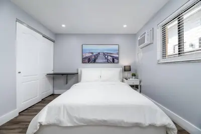 a white bedroom with a bed and a bridge at Shell on the Beach 102 - RENOVATED in Hollywood