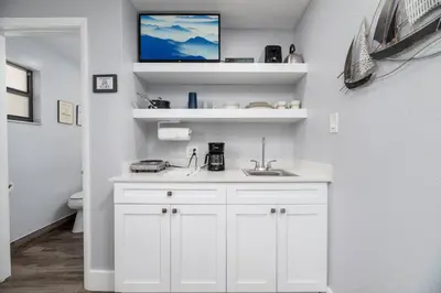 a bathroom with a sink and a tv on a wall at Shell on the Beach 102 - RENOVATED in Hollywood