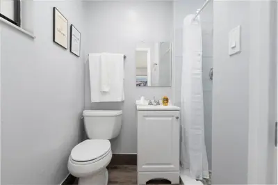 a white bathroom with a toilet and a shower at Shell on the Beach 102 - RENOVATED in Hollywood